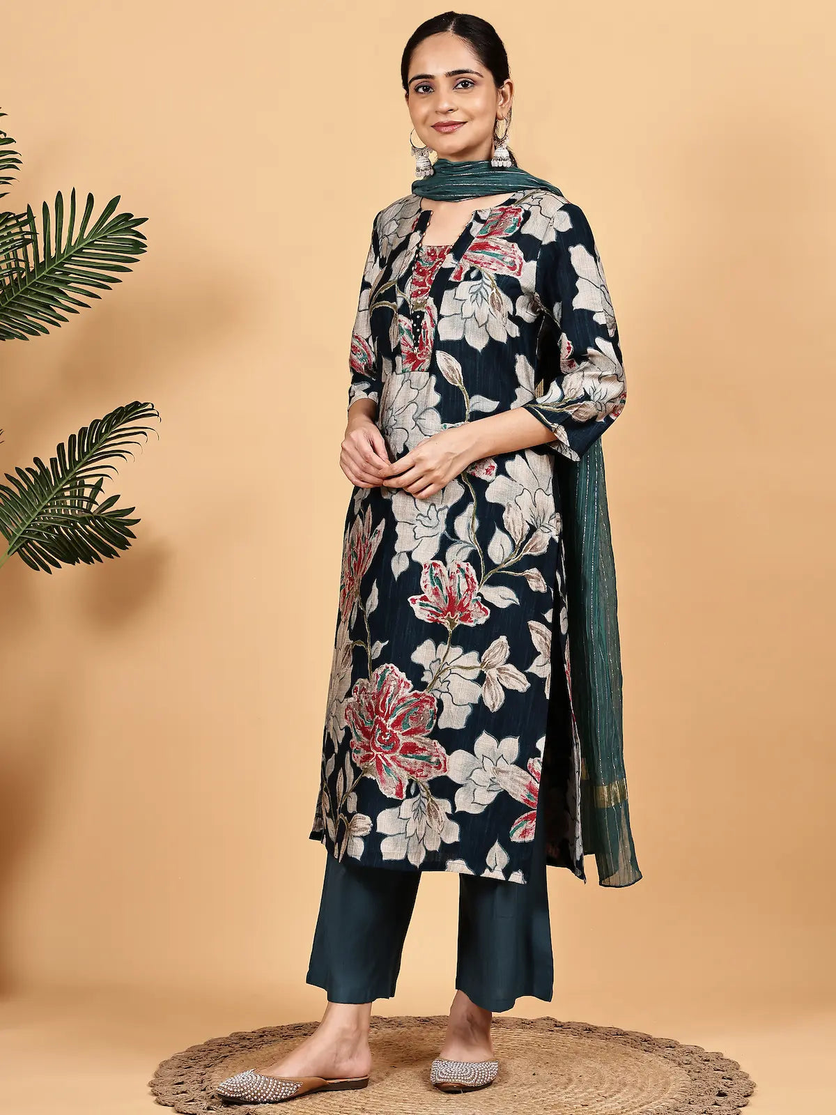 Woman wearing a floral kurta with a plain dupatta on a beige background