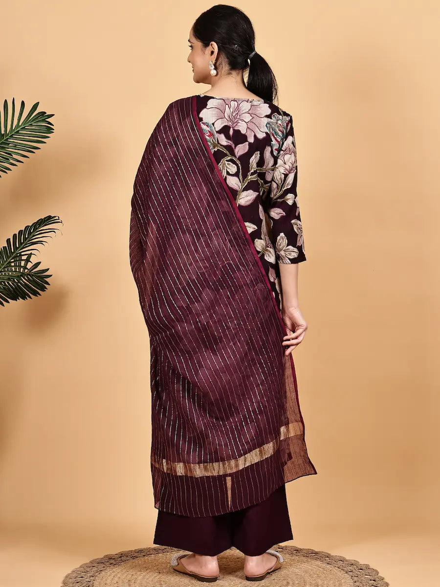 Woman wearing a dark purple saree with a floral blouse against a beige background