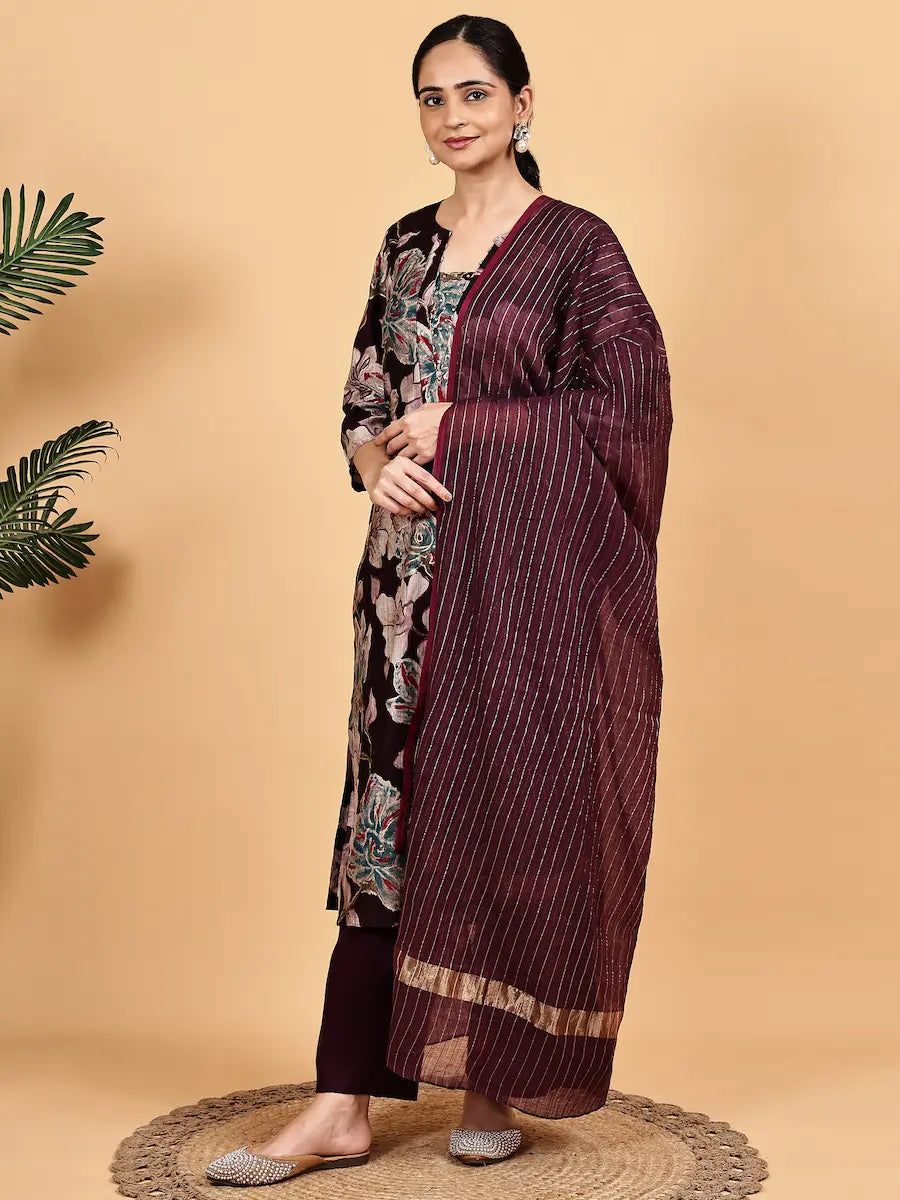 Woman wearing a maroon saree with white stripes on a beige background