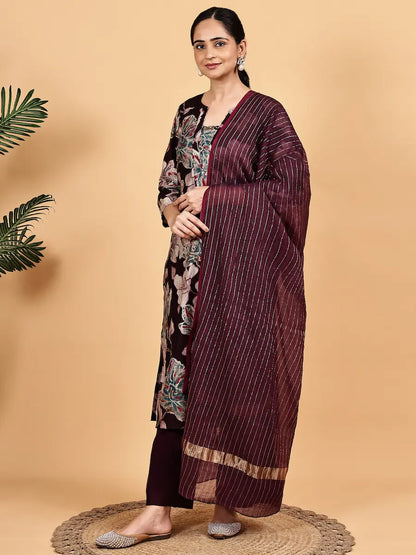 Woman wearing a maroon saree with white stripes on a beige background