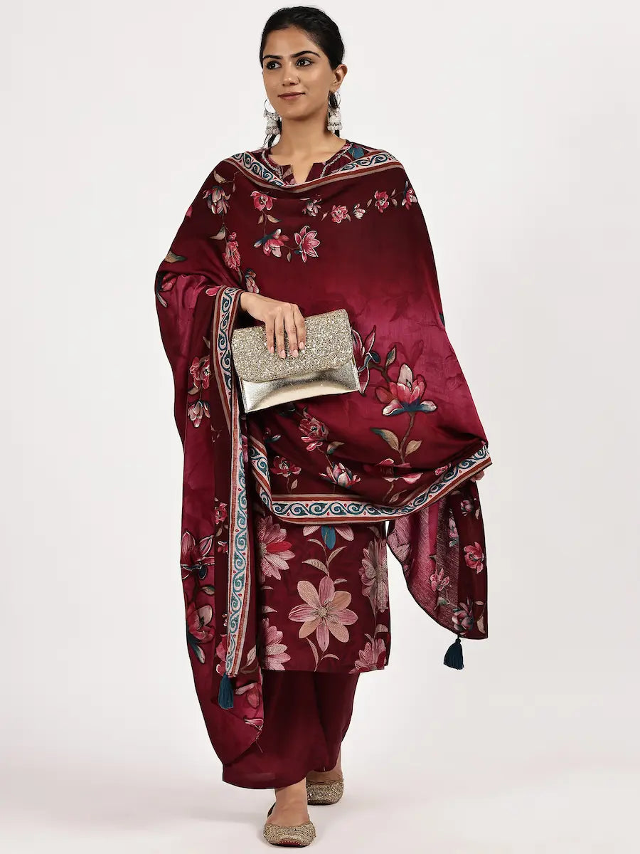 Woman wearing a maroon floral traditional outfit with a clutch on a white background