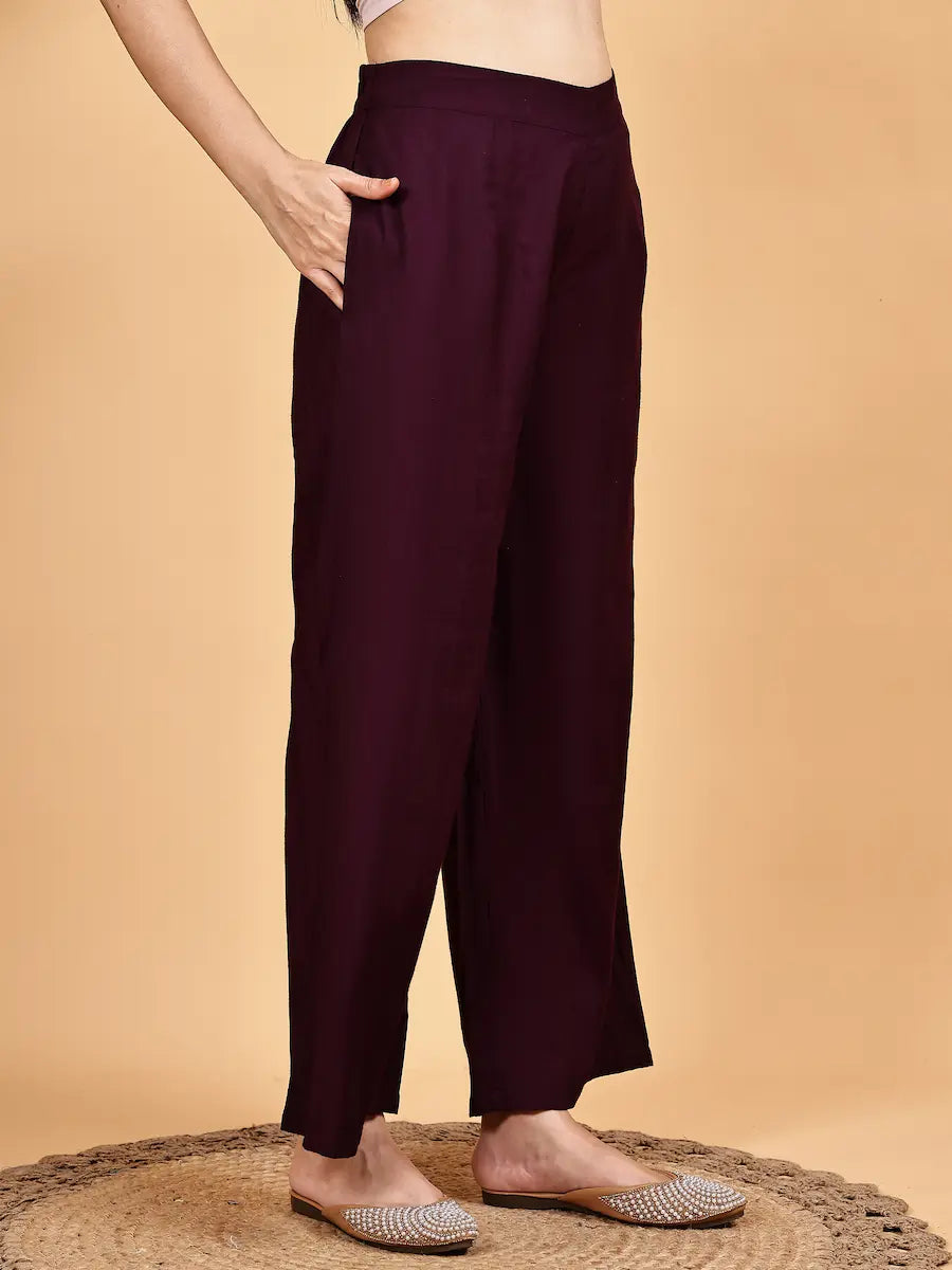 Maroon pants worn by a person on a beige background