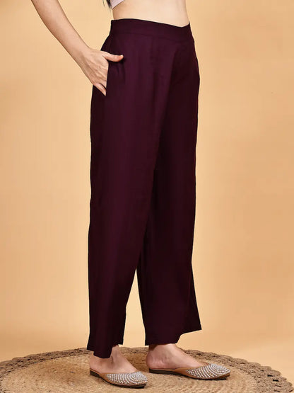 Maroon pants worn by a person on a beige background