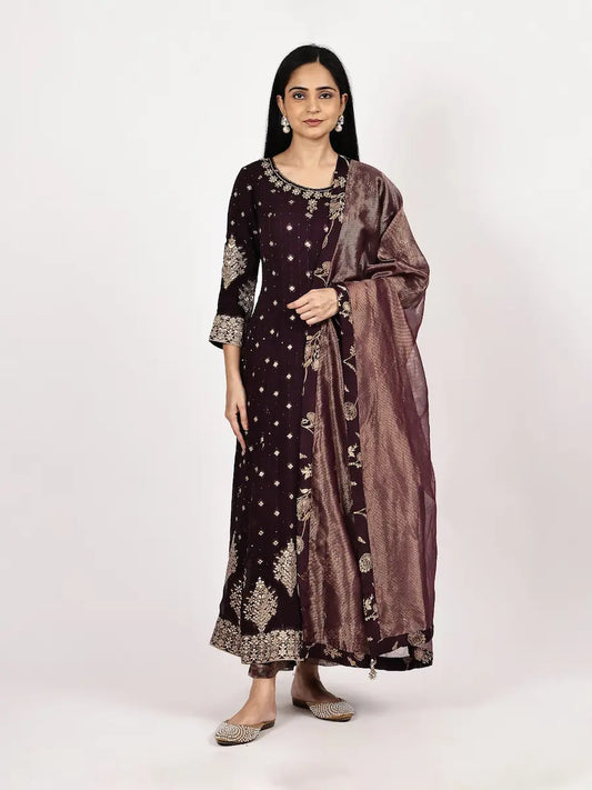 Woman wearing a dark purple traditional outfit with a matching dupatta on a white background